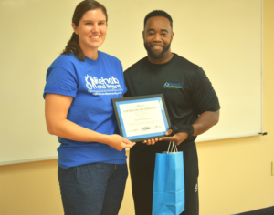 Two Rehabilitative Therapists, one male and one female, from Rehab and Beyond Non-profit Stand together holding National Stroke and Brain Injury Continuum Care Certification that female therapists has recently earned